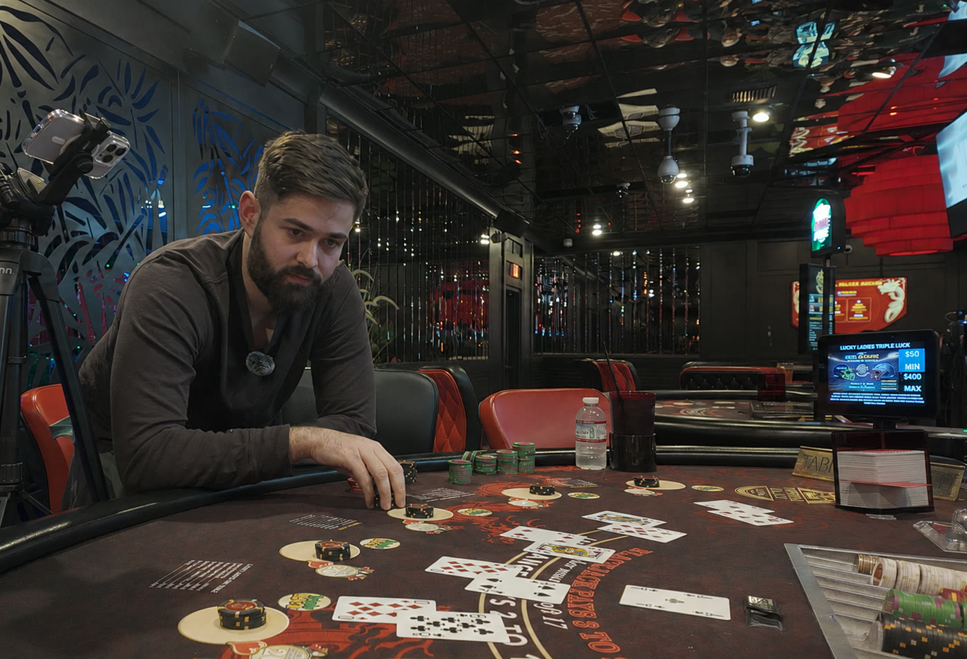Diego leaning over a live blackjack table mid-session, chips in hand