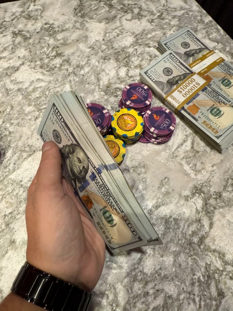 Handful of hundreds with $10,000 straps and chips on the counter